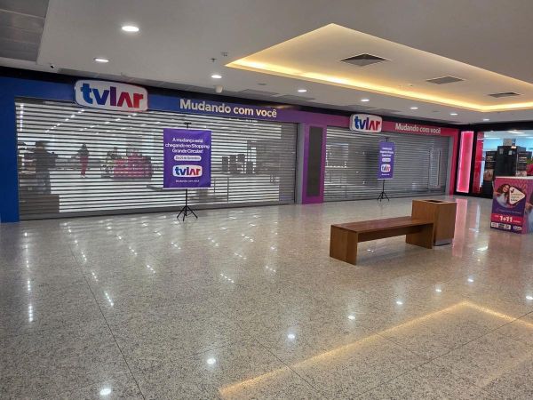 Fachada da loja TVLAR com grades fechadas e cartazes de inauguração no Shopping Grande Circular, em Manaus.