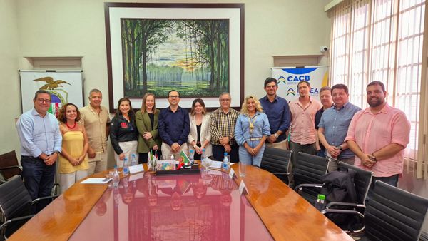 Representantes de entidades empresariais reunidos em volta de uma mesa de madeira na Associação Comercial do Amazonas.