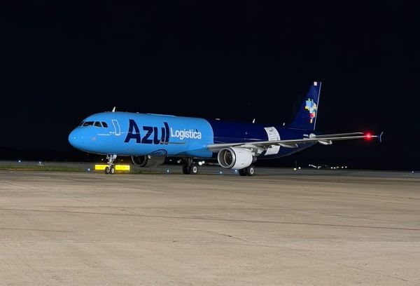 Aeronave cargueira azul e azul-marinho da Azul Logística estacionada na pista de um aeroporto durante a noite.