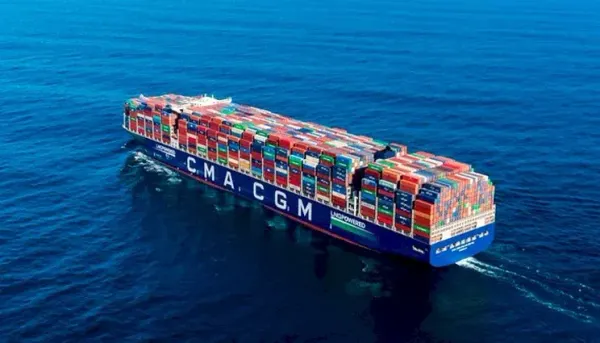 Navio porta-contêineres azul da CMA CGM carregado navegando em mar aberto.