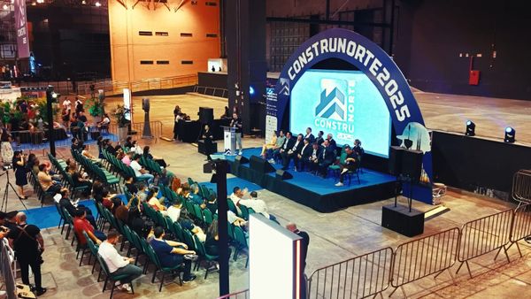 Palco com painel de LED da Construnorte e plateia sentada em cadeiras verdes durante palestra no Studio 5, em Manaus.