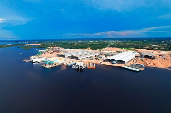 Vista aérea do Estaleiro Juruá em Iranduba, com galpões industriais e embarcações às margens do Rio Negro.