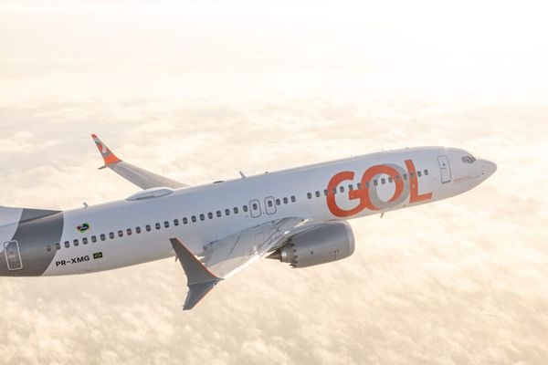 Aeronave da Gol Linhas Aéreas branca com detalhes em laranja sobrevoando nuvens.