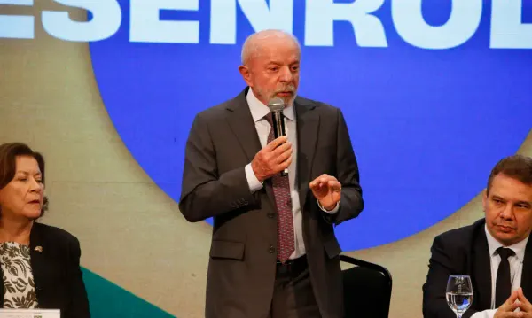 O presidente Lula discursa em evento no Palácio do Planalto com painel do programa Desenrola ao fundo.