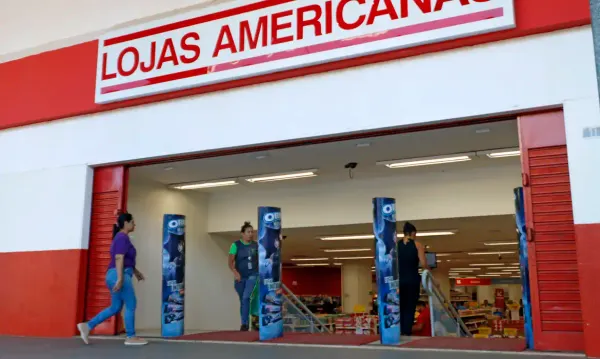 Fachada de uma unidade das Lojas Americanas com clientes entrando no estabelecimento.