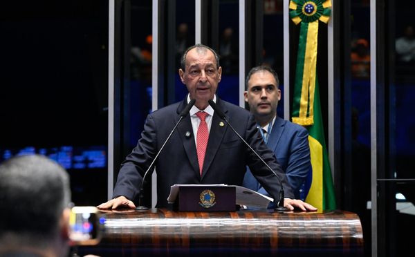 O senador Omar Aziz discursa em tribuna de madeira no Plenário do Senado Federal, com a bandeira do Brasil ao fundo.