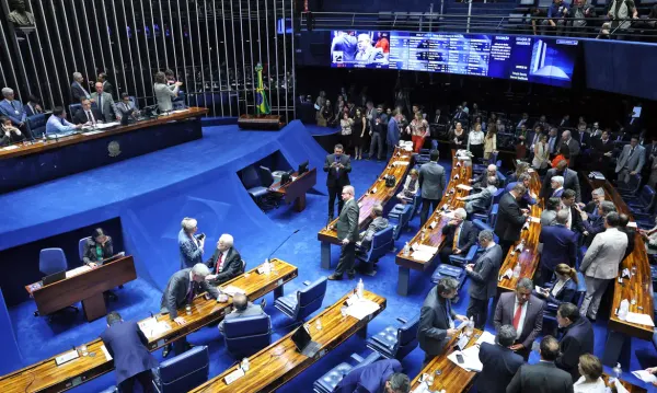 Plenário do Senado Federal em Brasília com parlamentares e assessores circulando entre as bancadas durante sessão.
