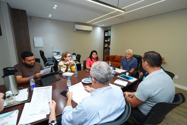 Integrantes do comitê gestor do Distrito de Inovação reunidos em volta de uma mesa de madeira na sede da Semtepi, em Manaus.