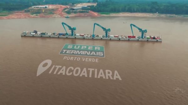 Píer flutuante do Super Porto Verde em Itacoatiara com três guindastes elétricos azuis operando no Rio Amazonas.