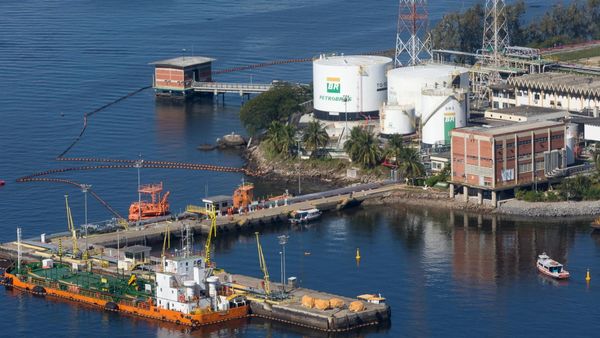 Vista aérea de terminal da Transpetro com tanques da Petrobras e embarcações atracadas em píer.