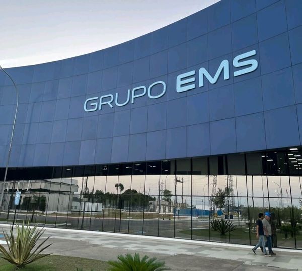 Fachada azul espelhada com o letreiro Grupo EMS em destaque, em Manaus.
