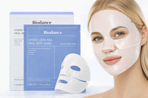 Woman wearing a hydrogel face mask next to BIODANCE Hydro Cera-nol Real Deep Mask packaging, showcasing a hydrating overnight skincare treatment for deep moisture and soothing care.