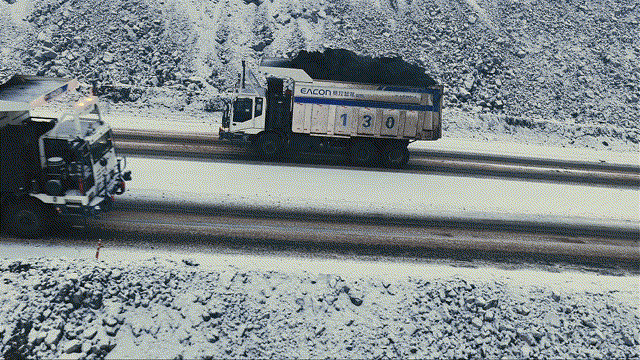 A driverless mining truck loaded with coal on a haul road at an open-pit mine
