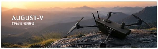A dark quadcopter drone sits on a rocky hilltop at sunrise.