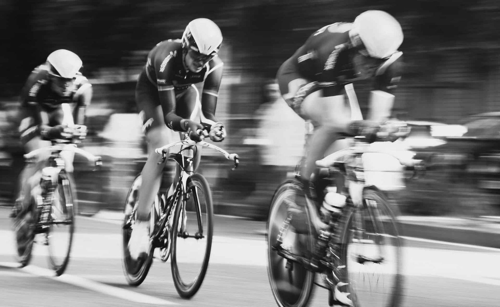 Three cyclists riding in a peloton
