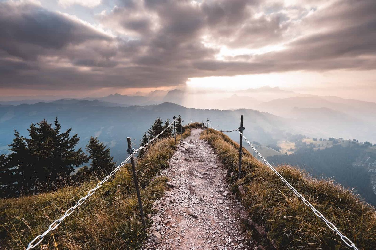 Photograph of a narrow trail leading scross a mountain range.
