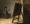 Rembrandt painting of a small figure in a tabard standing across a sparse studio, holding brushes and a palette, gazing at a large easel with its back turned to the viewer.