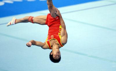 Chinese gymnast completing straddle somersault on floor exercise