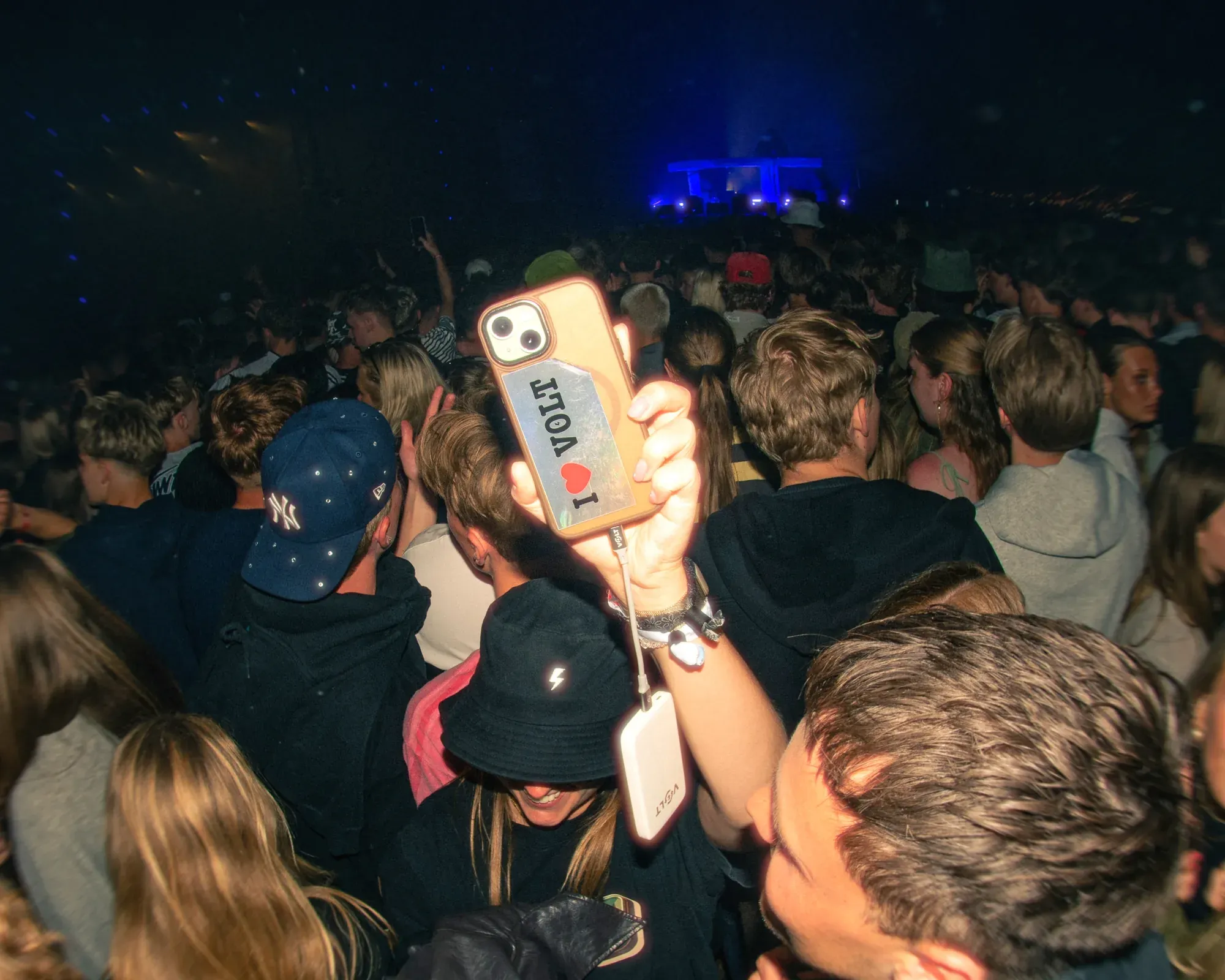 Branded phone case and Volt powerbank in a festival crowd