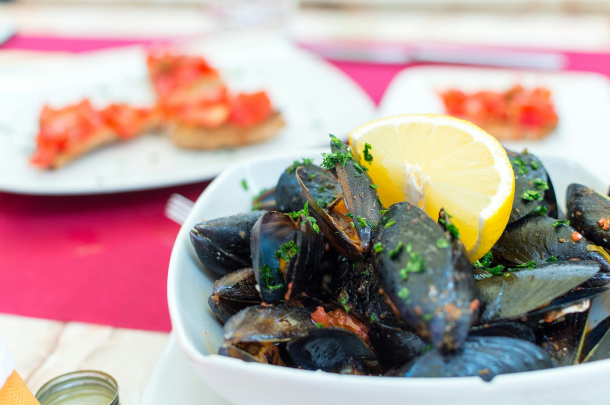 Mussels prepared in a healthy tomato broth topped with chives and lemon