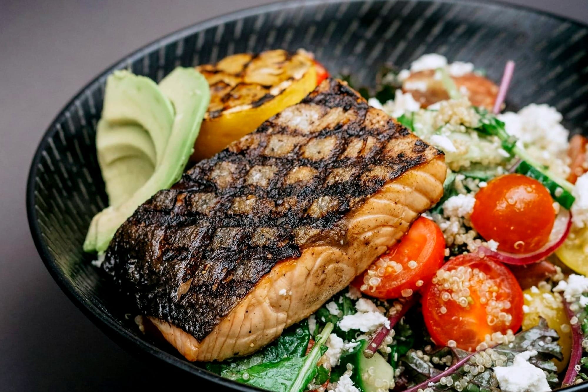 grilled salmon over a nutritious salad in a bowl