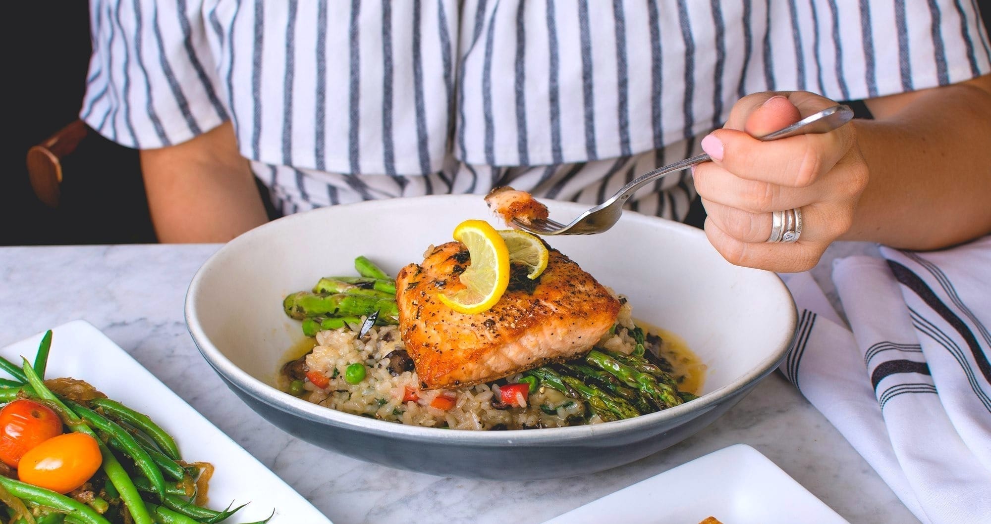 Woman eating grilled salmon