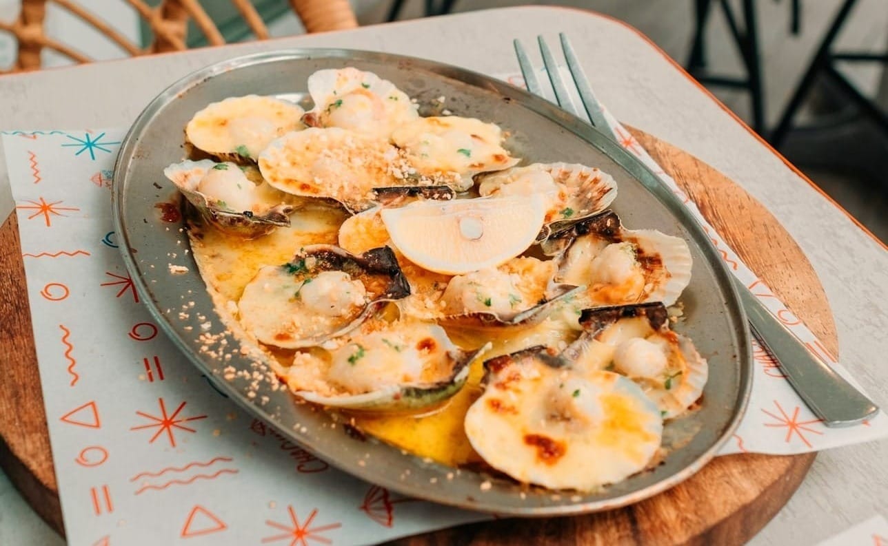 a plate of baked scallops sitting on top of a table