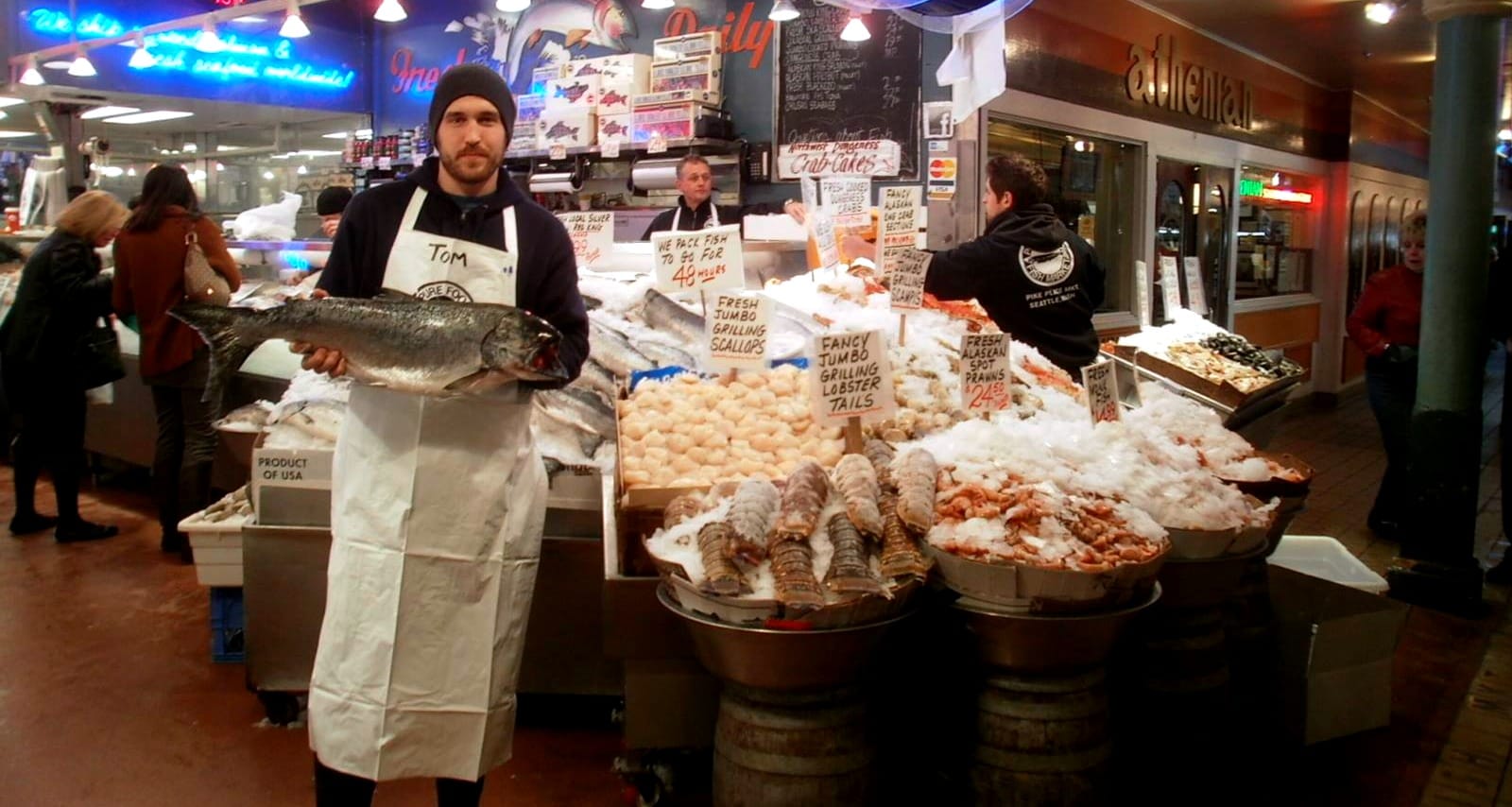 Fishmonger presenting a whole fish at a fish market