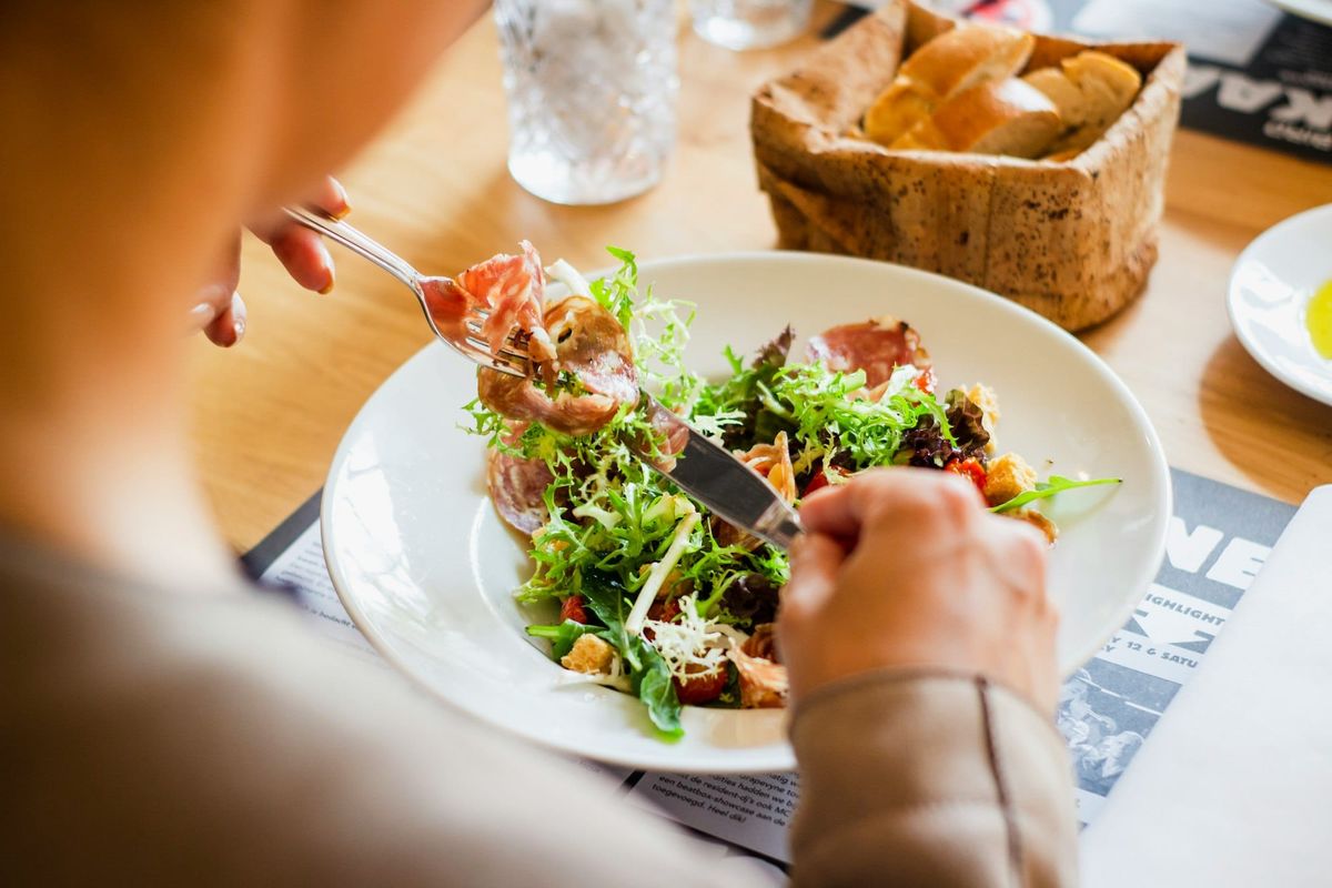 Woman eating a nutritious salad with salmon from a bowl