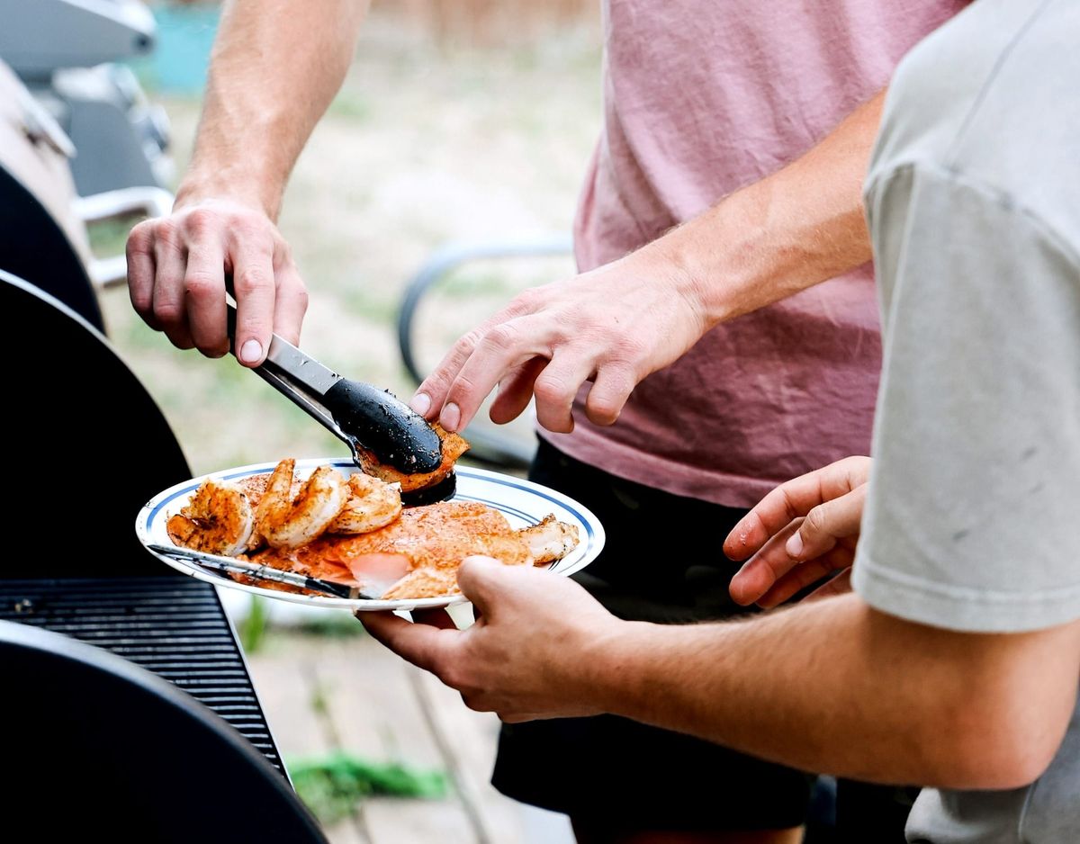 man grilling seafood for others