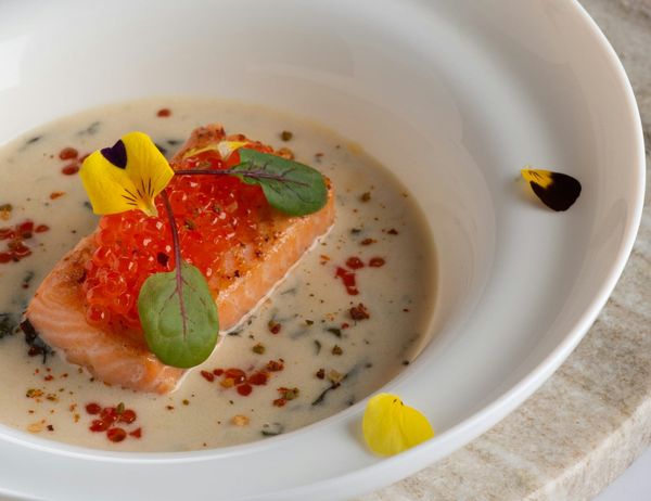 Poached fish filet and sauce in a white bowl