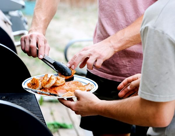 man grilling seafood for others