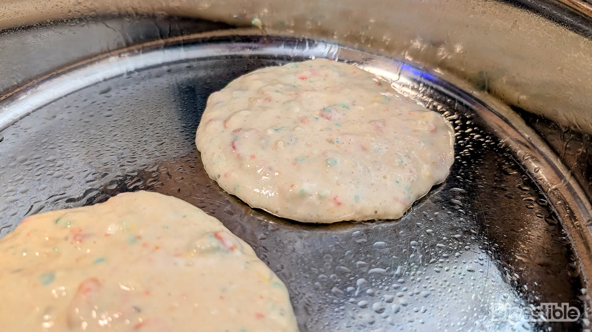Pancakes cooking in a pan.