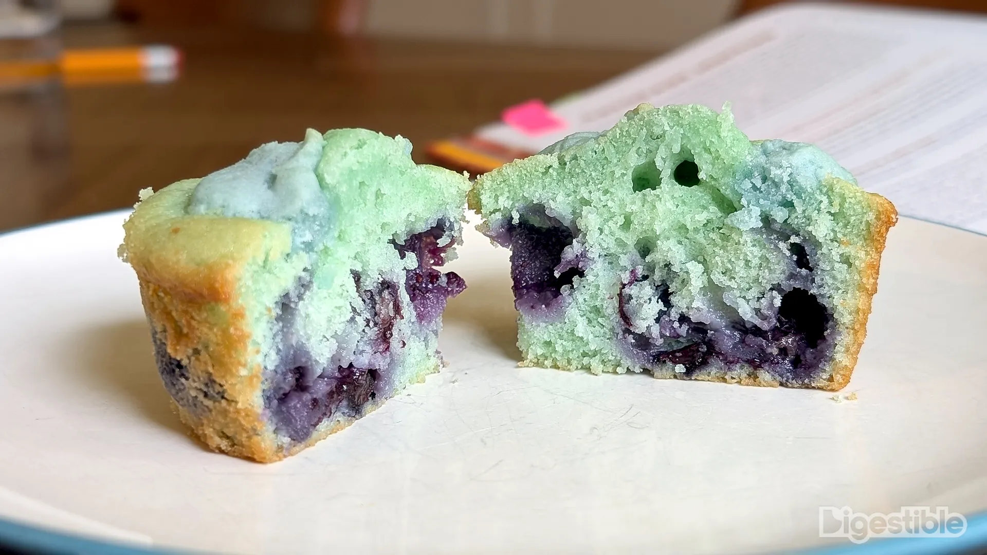 A blue muffin with blueberries sliced in half.