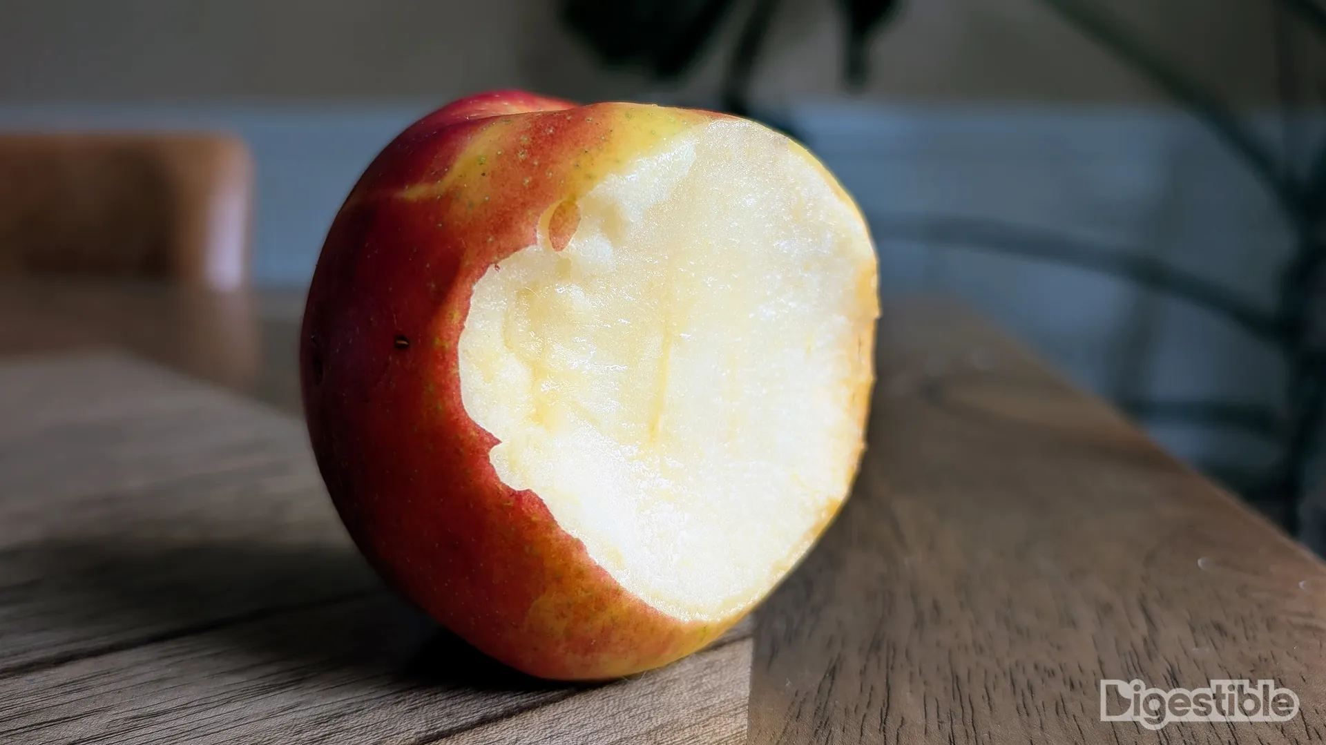 A red and yellow apple with a bite taken out.