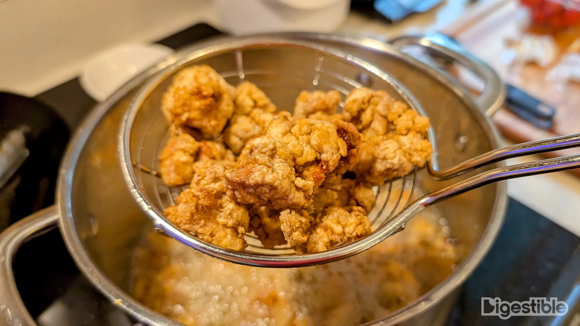 Deep fried chicken chunks in a spider above oil