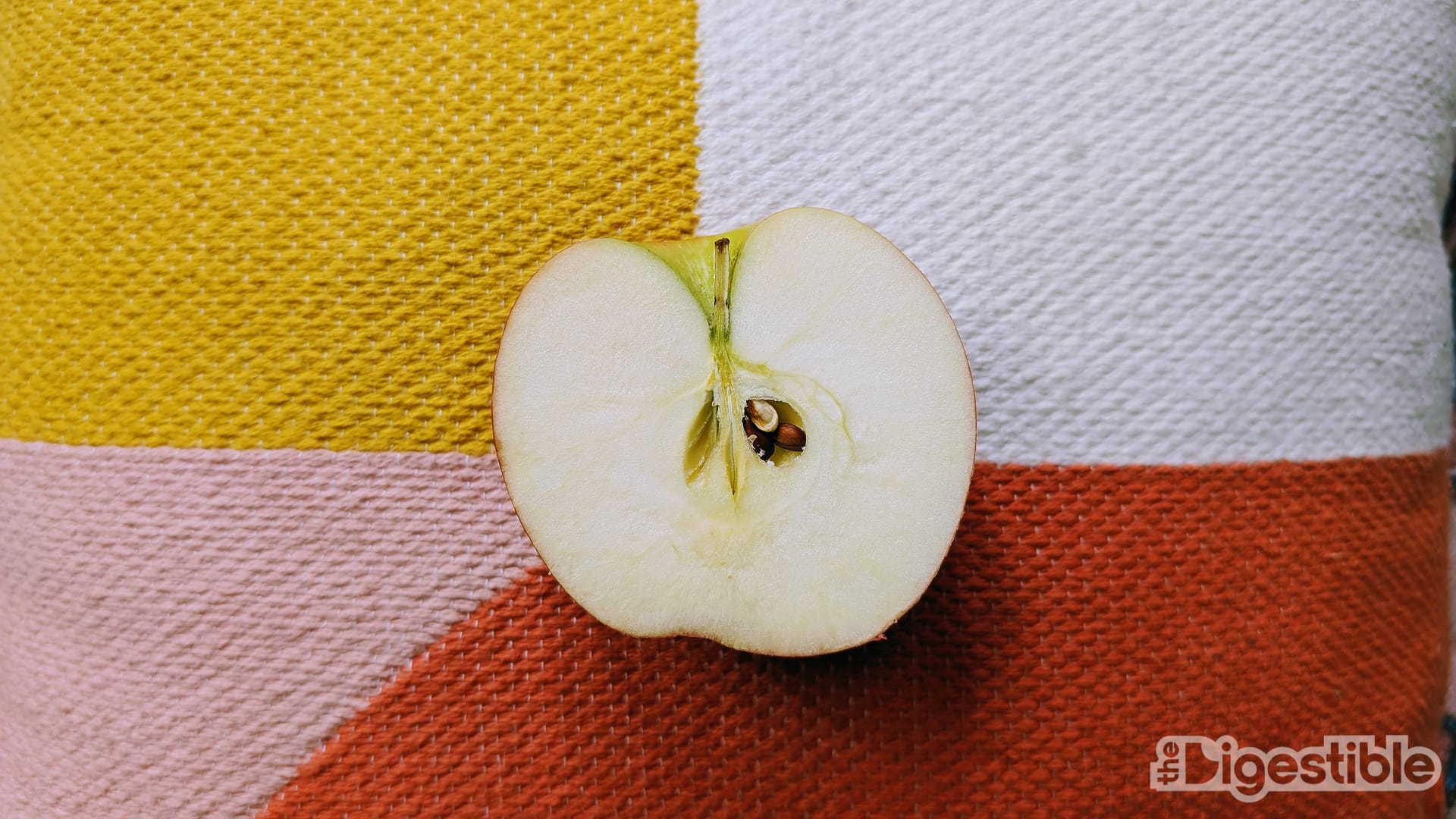 A pink lady apple sliced in half.