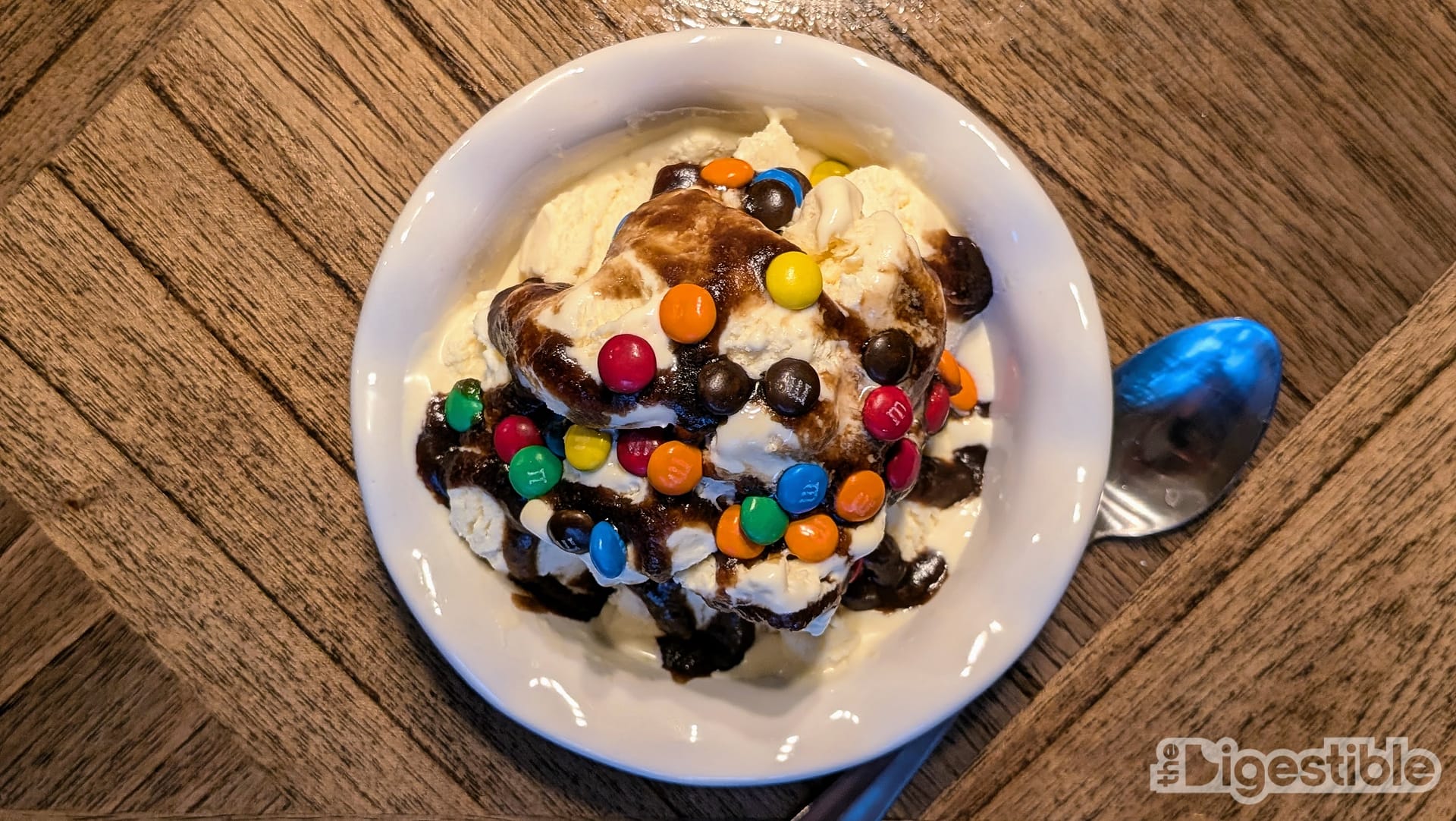 Top down view of an ice cream sundae with M&Ms on top.