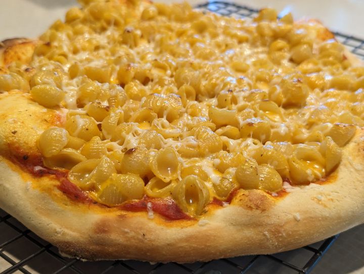 Mac and cheese noodles on a pizza.