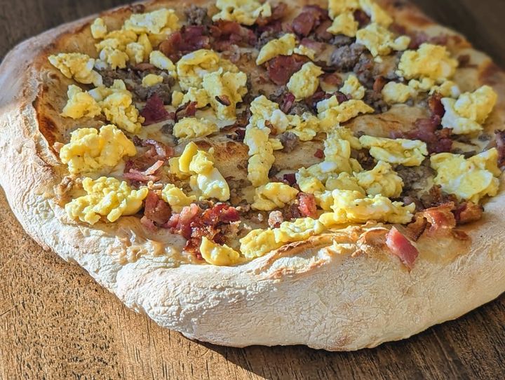 Bacon, sausage, and eggs on pizza.