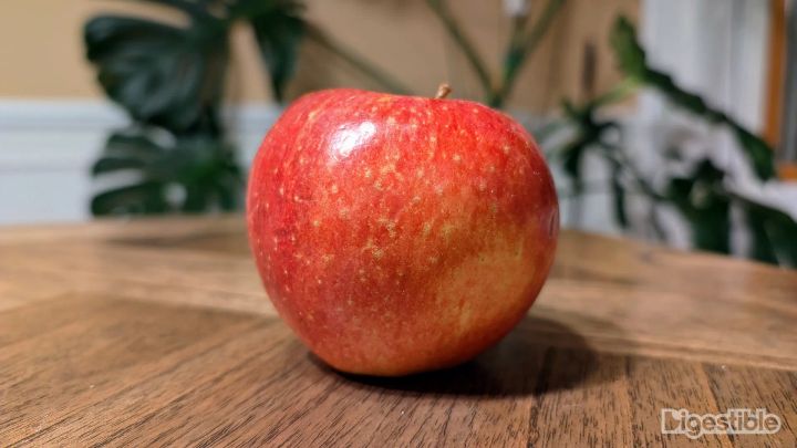 A red Wild Twist apple on a table.