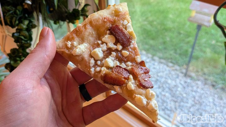 A slice of pizza with rhubarb sauce, feta, and bacon.