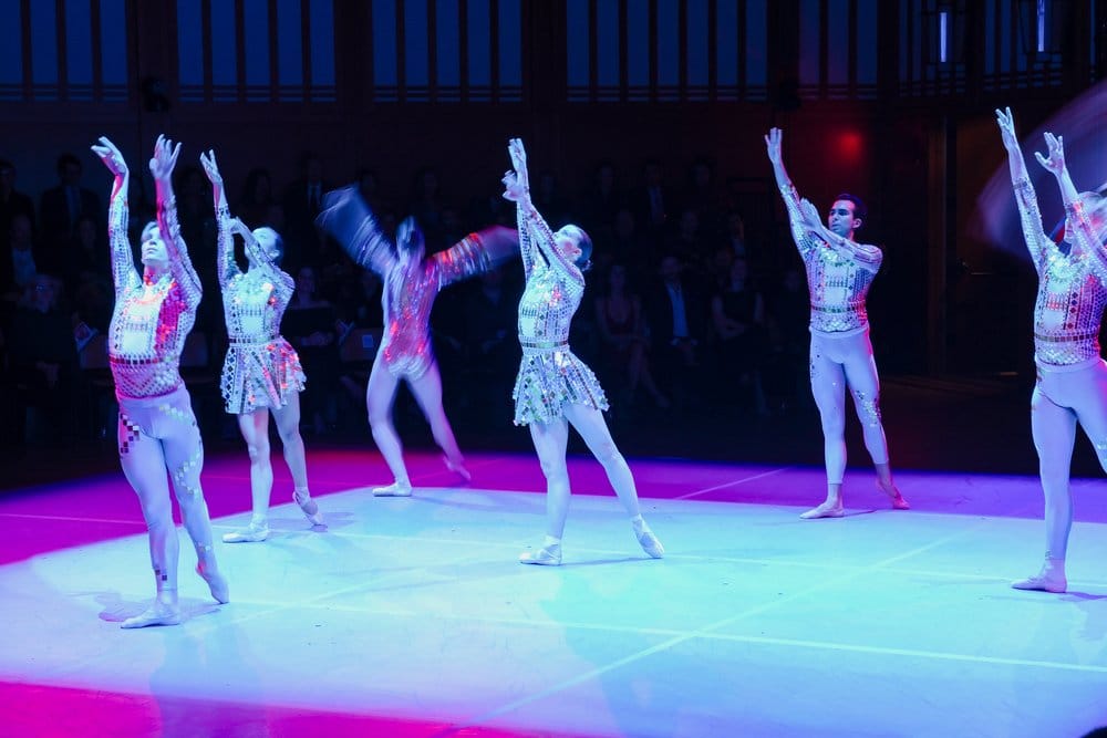 Six ballet dancers performing The World We Left Behind. Five have their arms reaching towards the sky, while the sixth dances with both arms raised.