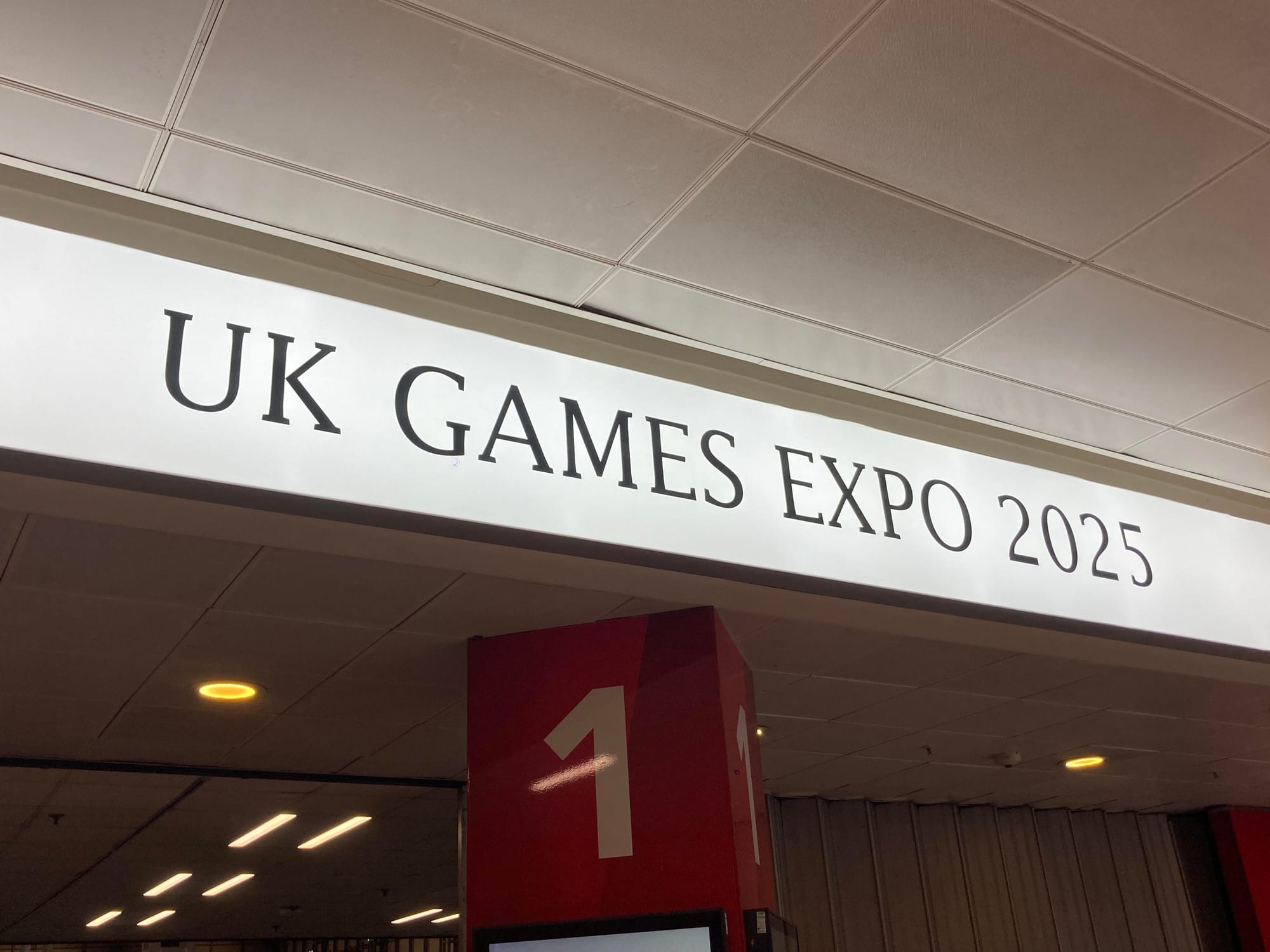 Sign reading "UK Games Expo 2025" above the entrance to Hall 1