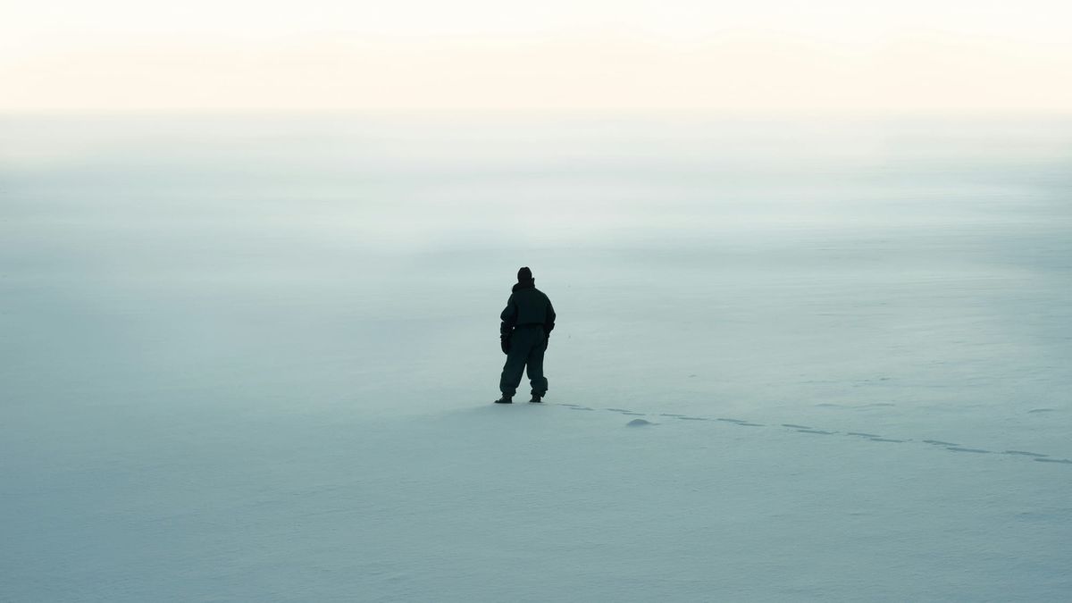A photo of a snowy landscape with a prominent silhouette of a figure in the center.