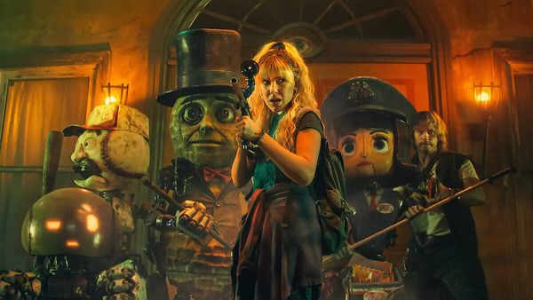 Millie Bobby Brown and Chris Pratt in ensemble shot with a bunch of robots from The Electric State, including Mr. Peanut