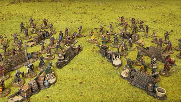 A photo of The Barons' War miniatures arranged in a dramatic face-off on a green grass gaming board.