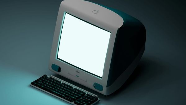 Old, teal, desktop iMac with keyboard and a blank, white screen.