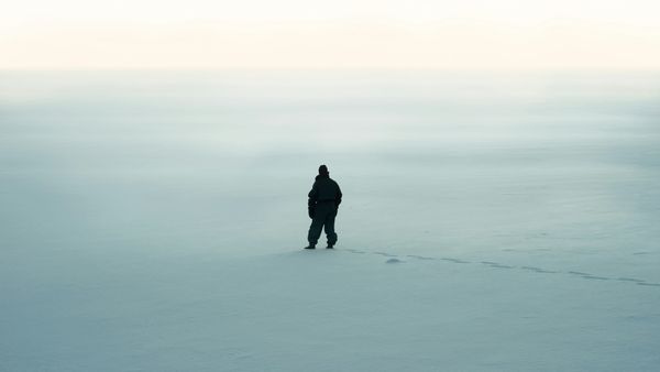 A photo of a snowy landscape with a prominent silhouette of a figure in the center.