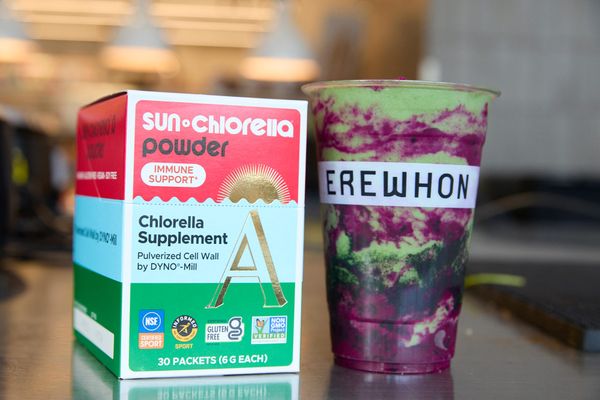 Box of chlorella powder next to a purple-green Erewhon smoothie
